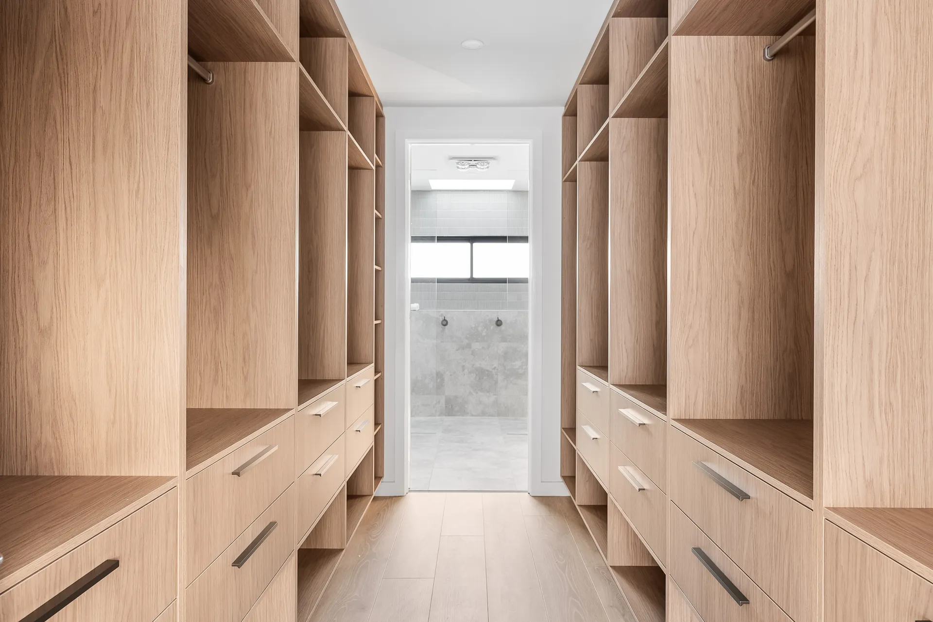 Walk-in robe with custom oak joinery leading to the ensuite in the Scott home