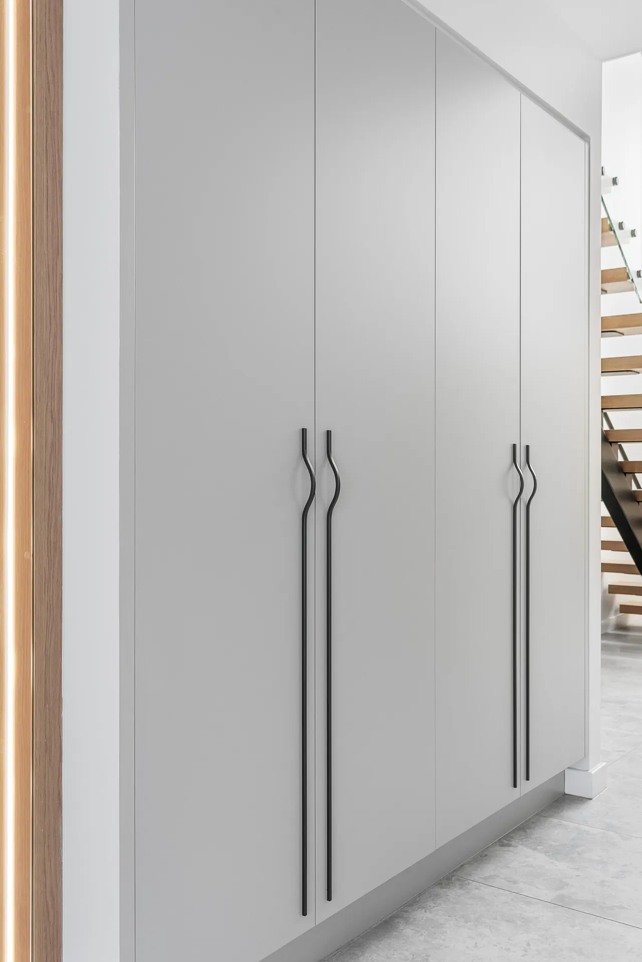 Full-height hallway joinery beside the floating staircase in the Scott home