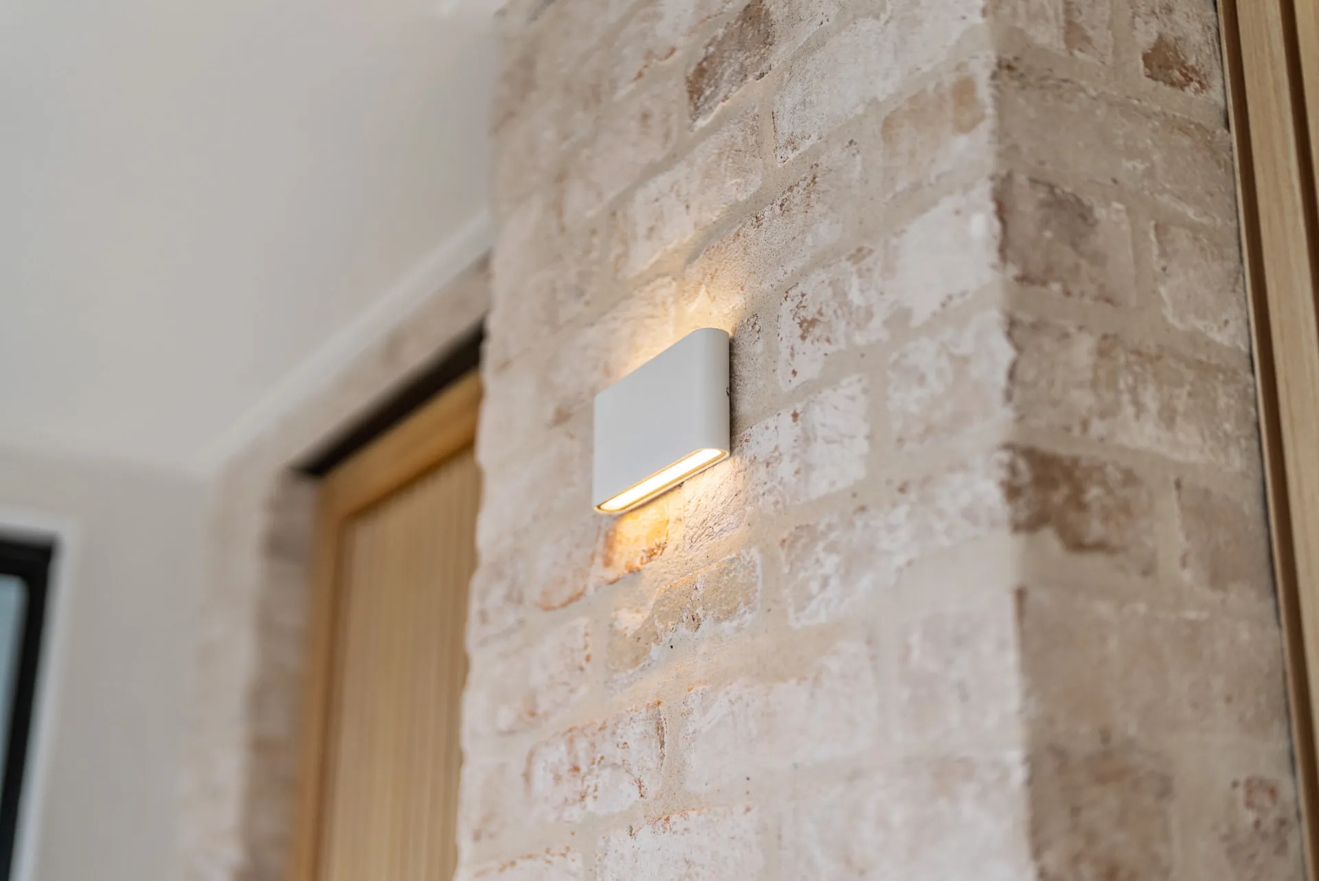 Wall light on the recycled brick entry pier of the Scott home
