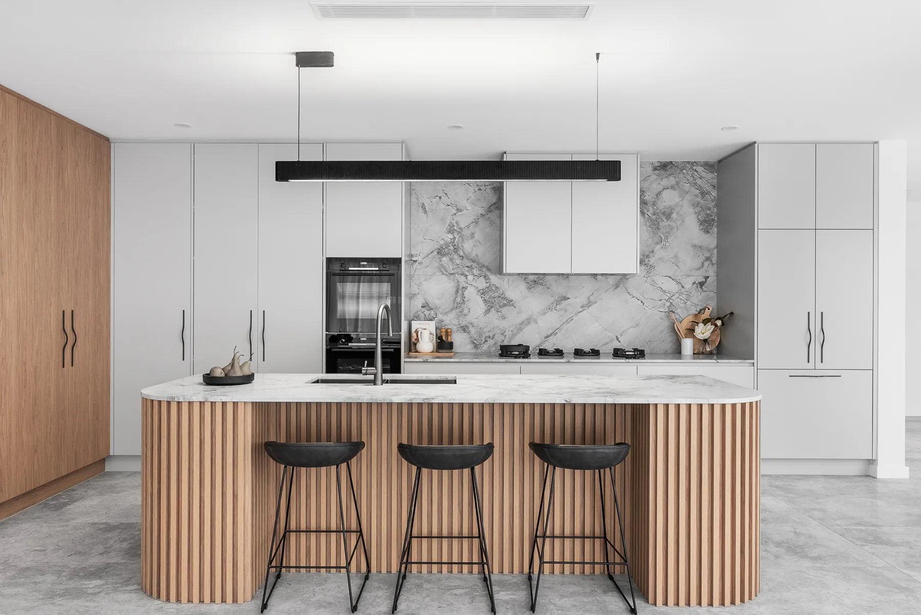 Kitchen with marble benchtop and fluted timber island in the Scott custom home