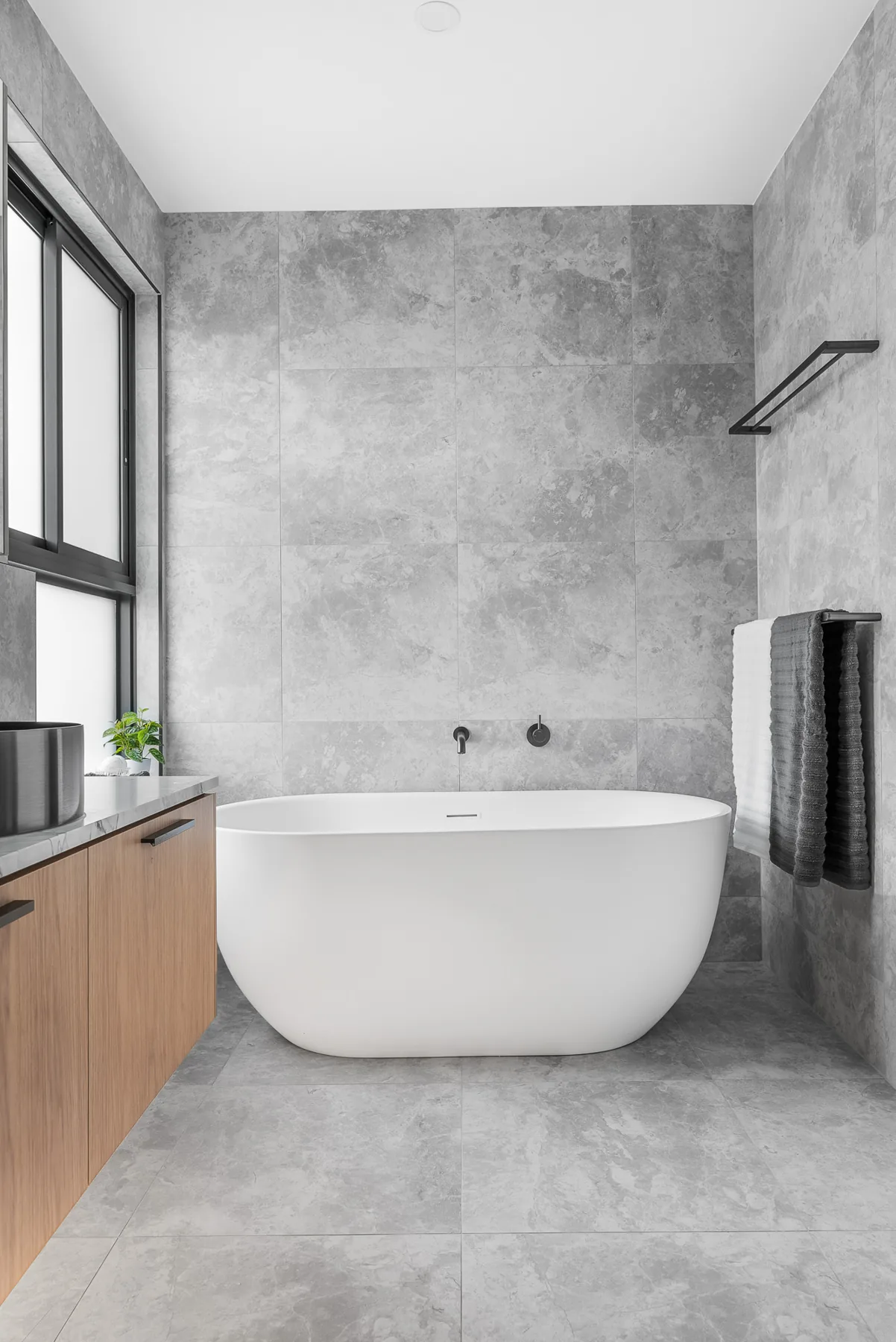 Freestanding bath and stone-look tiling in the main bathroom of the Scott home