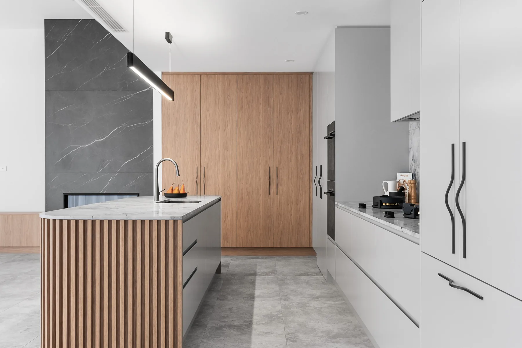 Kitchen island with marble benchtop looking through to the stone fireplace in the Scott home