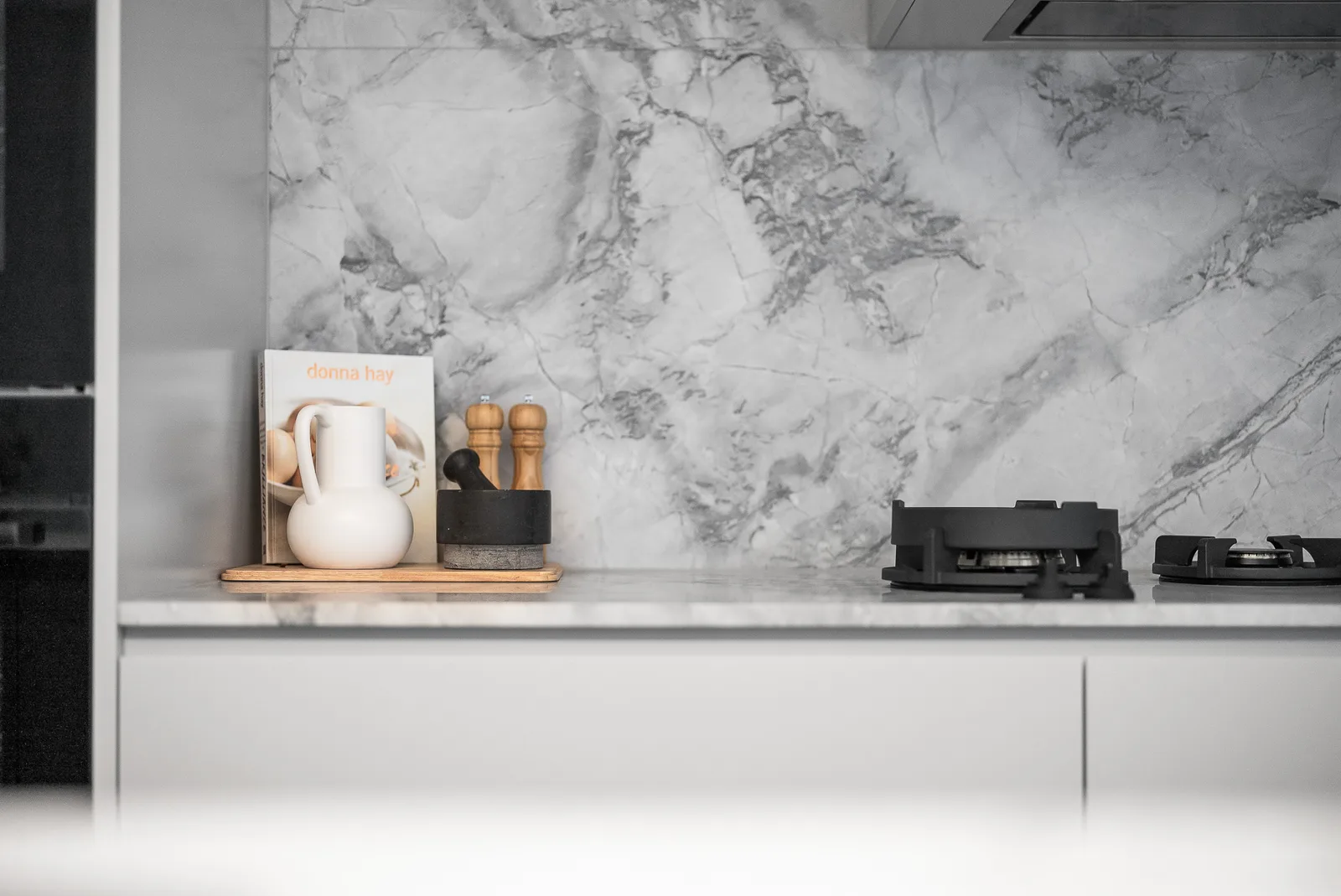 Marble benchtop and splashback beside the gas cooktop in the Scott kitchen
