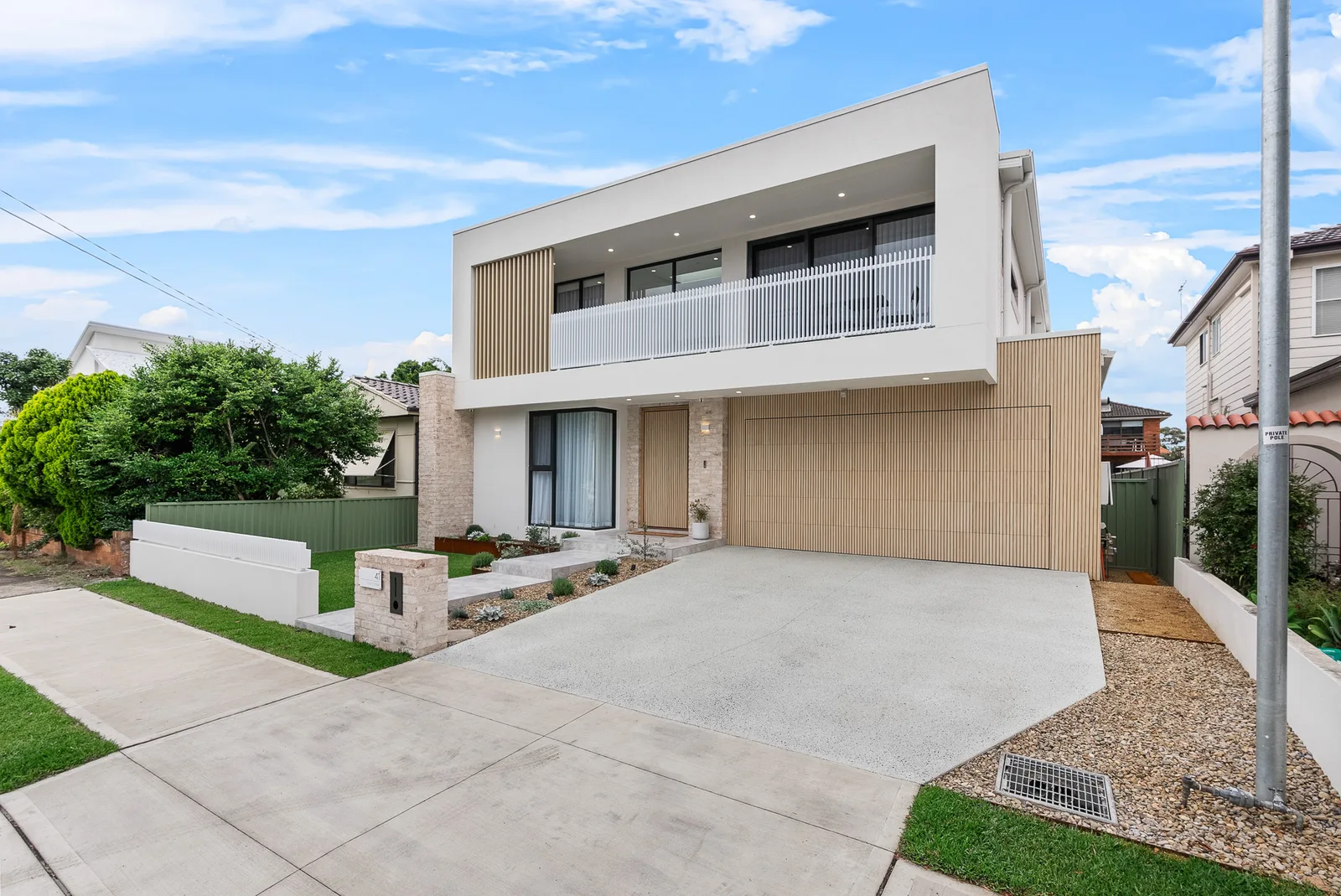 Street view of the completed Scott custom home with timber garage door and brick detailing