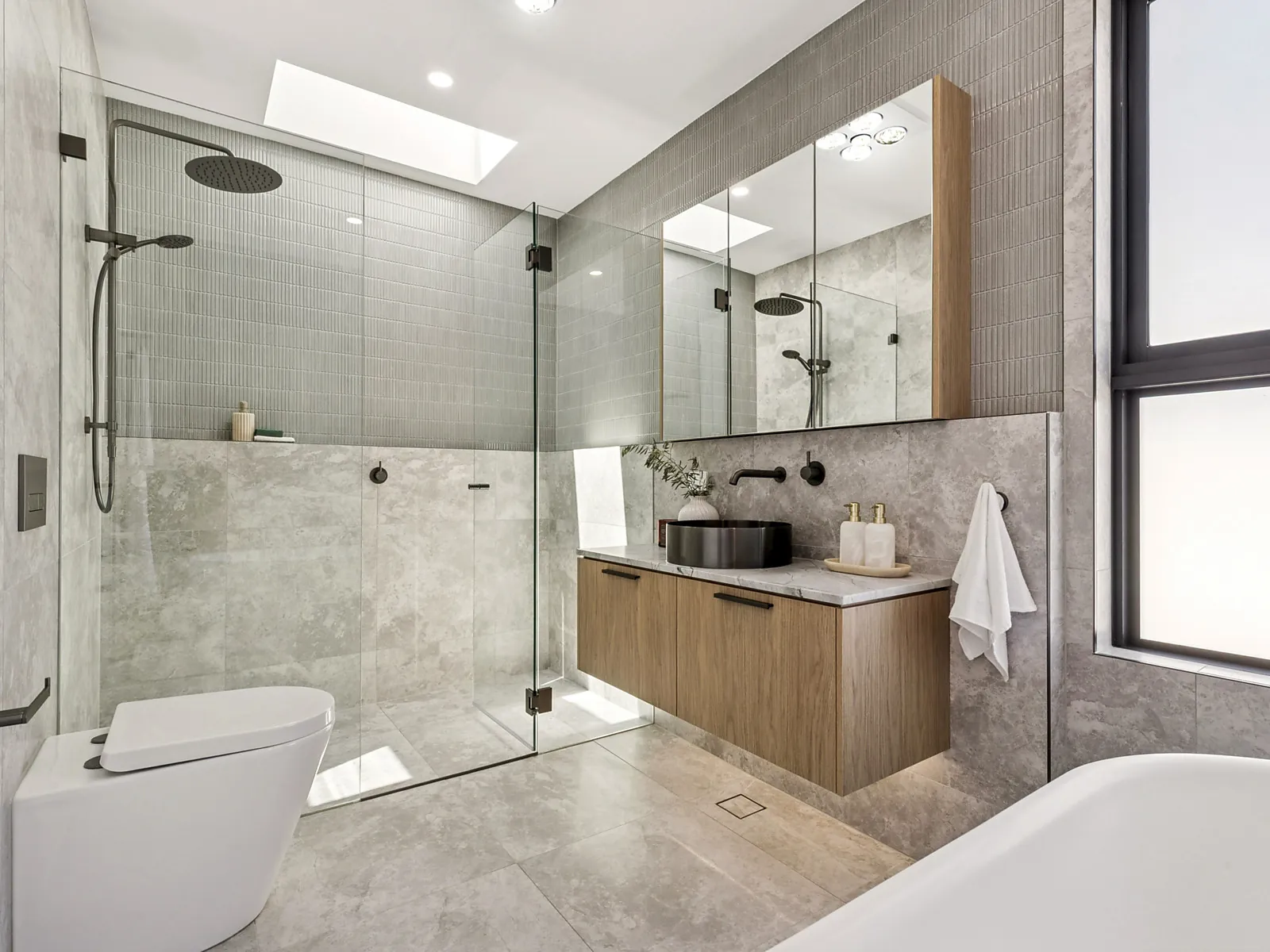 Bathroom with stone tiling and skylight in the Scott custom home