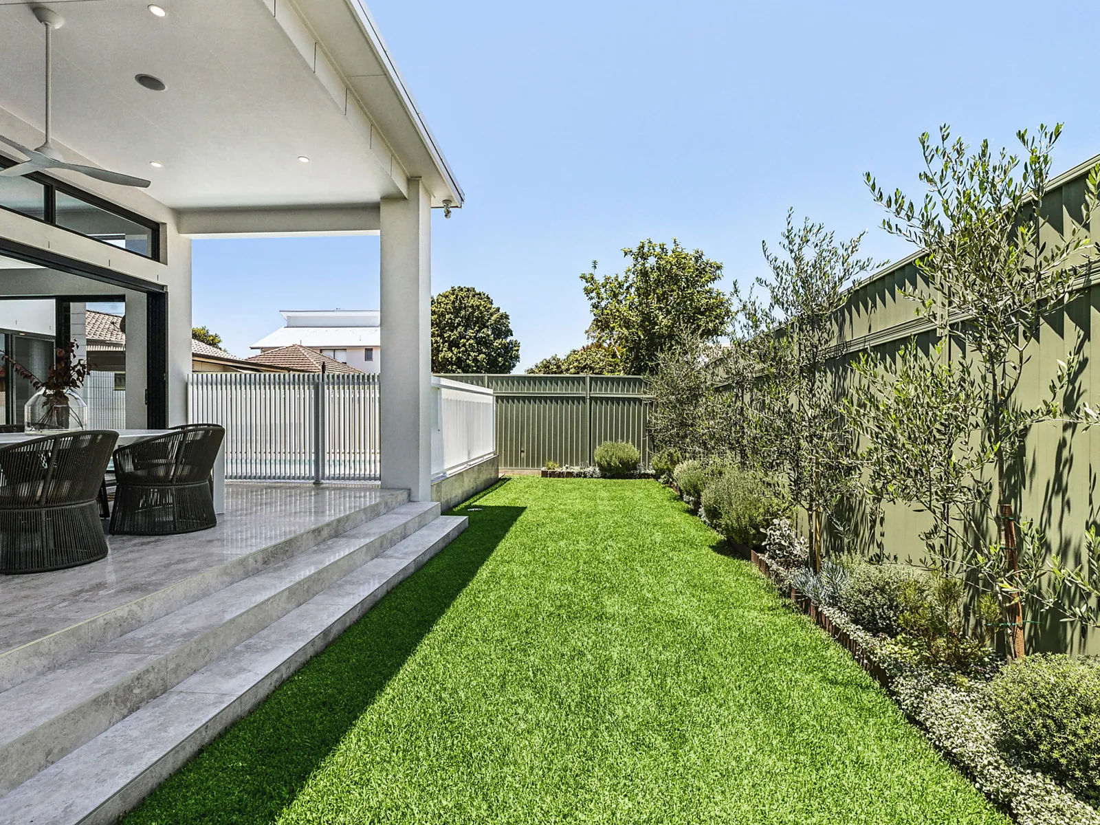 Landscaped lawn and covered terrace at the Scott home